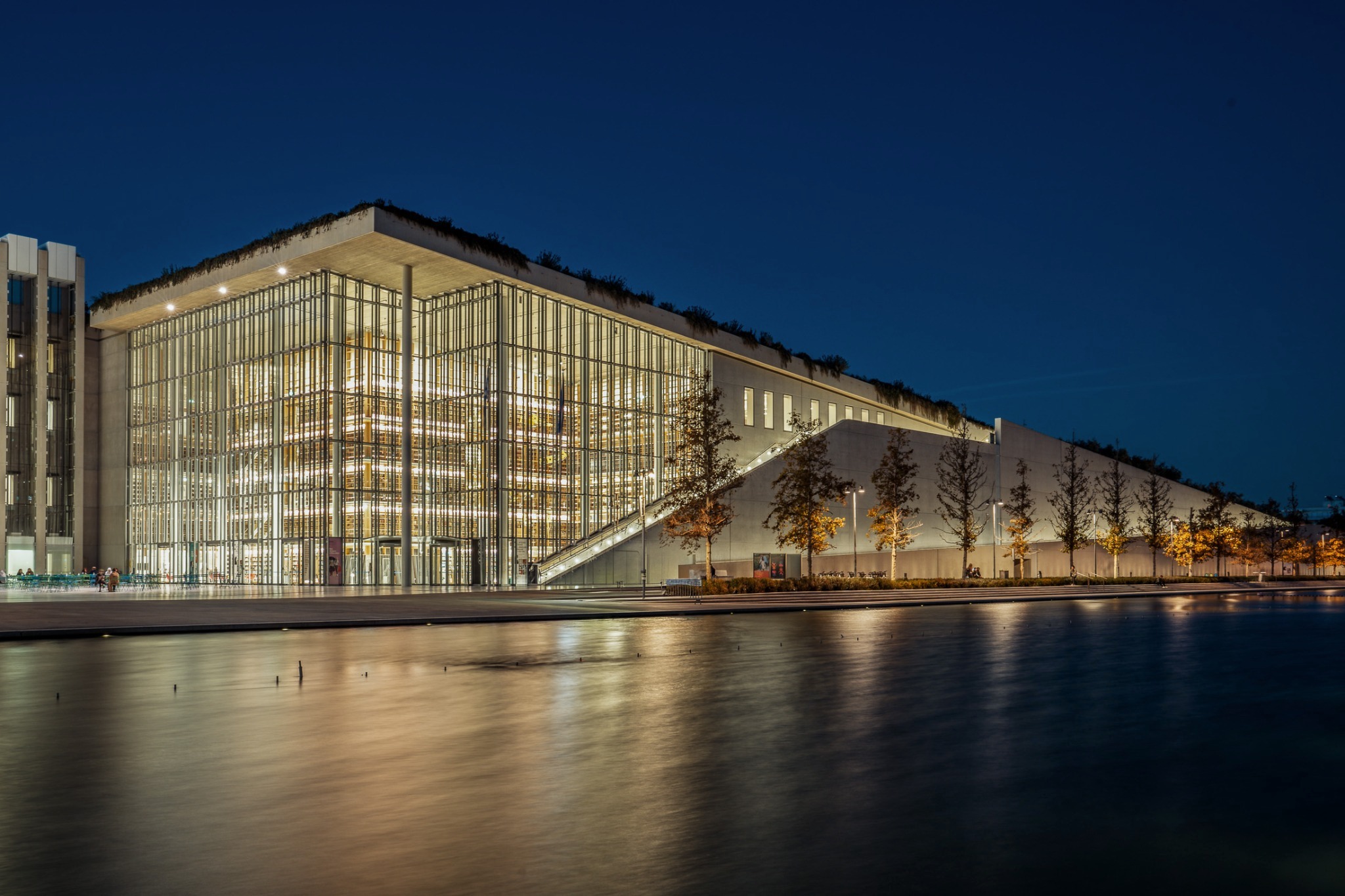 Stavros Niarchos Foundation Cultural Center — nighttime facade reflected in the canal