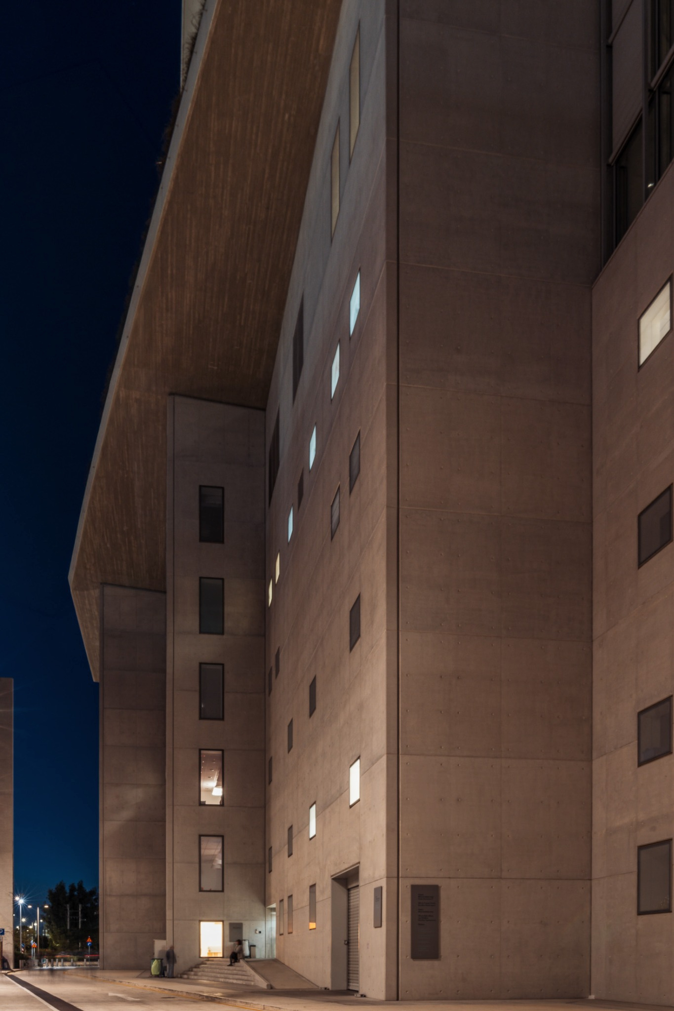 Stavros Niarchos Foundation Cultural Center — tall concrete elevation at night