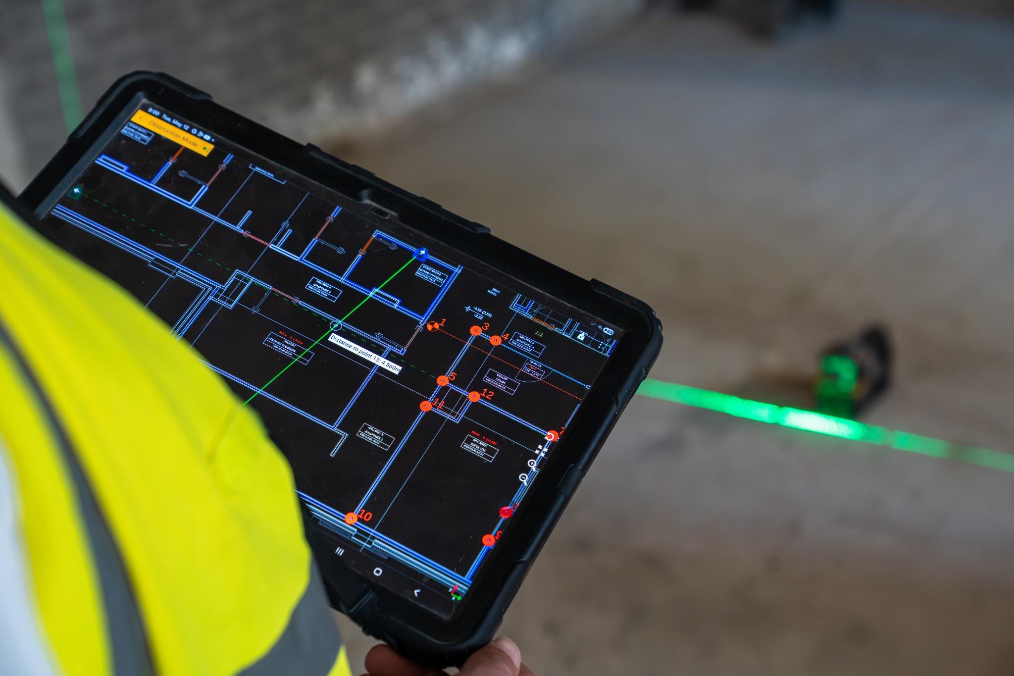 On-site measurement detail with a tablet and green laser